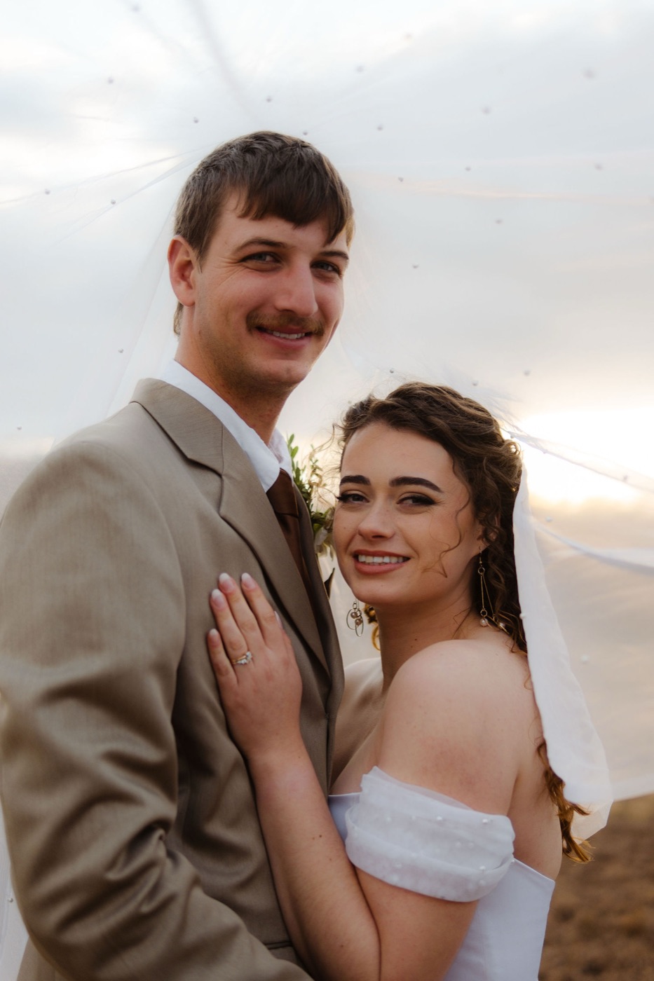 The Heymans: bride and groom smiling under her veil