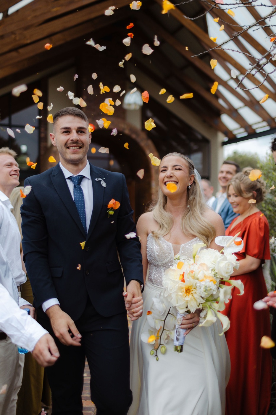 Le Roux wedding: couple walking through petal confetti
